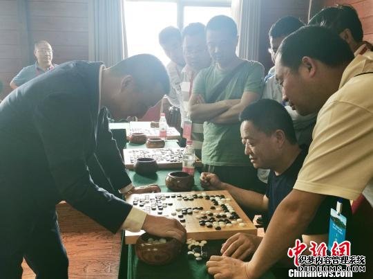 图为古力、常昊同时与22位来自全国各地的围棋爱好者进行“车轮战”指导棋现场。　胡腾 摄