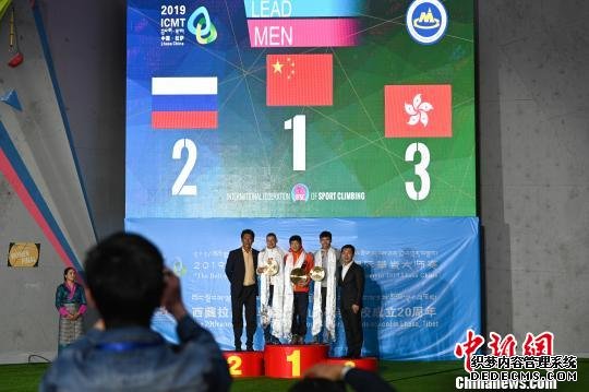 图为在11日举行的颁奖仪式上，获得男子难度赛冠军的中国选手马自达(中)，以及获得男子难度赛季军的中国香港选手游嘉俊(右二)与颁奖嘉宾合影。　何蓬磊 摄