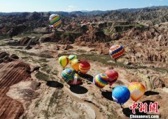 甘肃张掖七彩丹霞“牵手”热气球 游客众览“彩虹山”